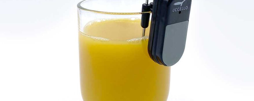 Liquid Level Indicator on the lip of a glass filled with orange juice
