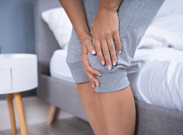 Woman holding her sore and painfull knee