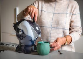 Elderly woman pouring a cup of tea with the Uccello Kettle