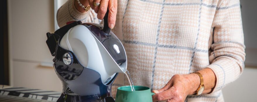Elderly woman pouring a cup of tea with the Uccello Kettle