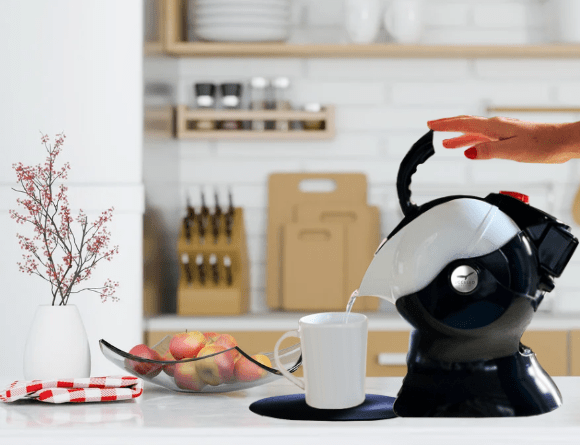 woman pouring the Uccello Kettle in her kitchen