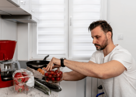 Wheelchair user in his adaptive kitchen preparing a meal