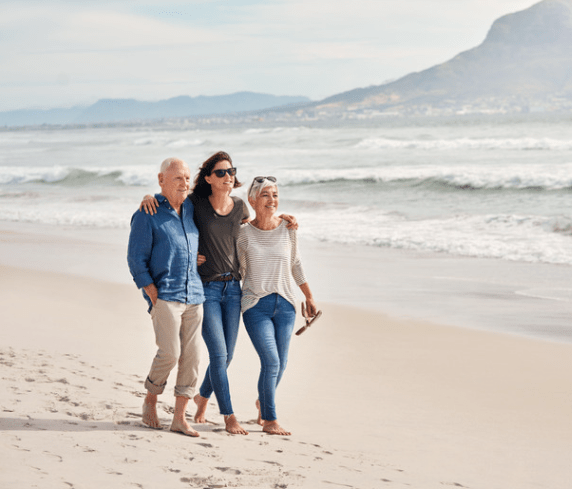 Elderly couple and daughter walking on the beech