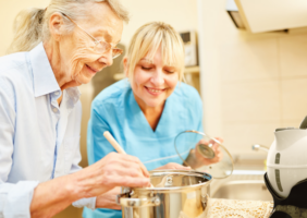 occupational therapist in the kitchen with elderly woman cooking