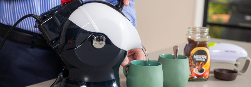Elderly man pouring the Uccello Kettle in the kitchen