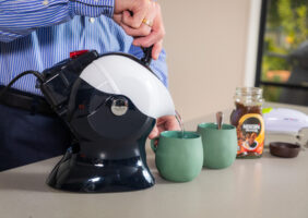 Elderly man pouring the Uccello Kettle in the kitchen