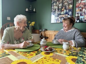 Mother and Daughter laughing together over a cuppa