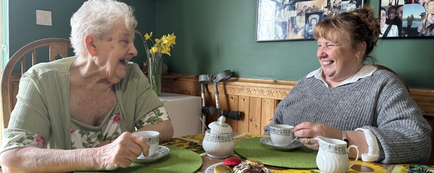Mother and Daughter laughing together over a cuppa