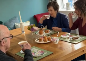 Adult daughter enjoying tea and cake with her mother and father