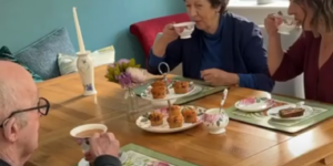Adult daughter enjoying tea and cake with her mother and father