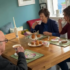 Adult daughter enjoying tea and cake with her mother and father