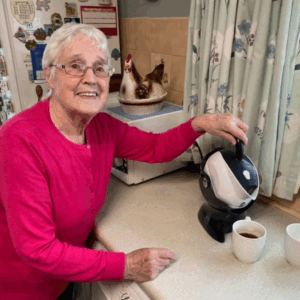 Elderly woman making tea using the Uccello Tipping Kettle