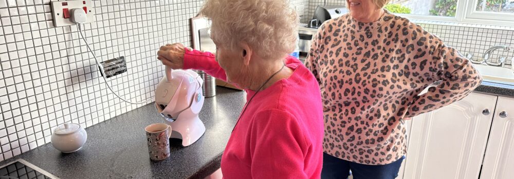 Elderly mother making tea in the kitchen with her daughter