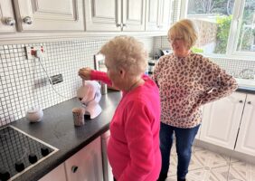 Elderly mother making tea in the kitchen with her daughter