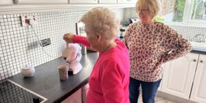 Elderly mother making tea in the kitchen with her daughter