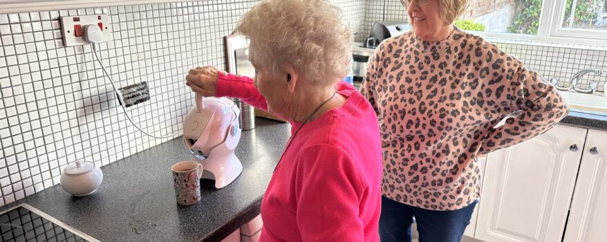 Elderly mother making tea in the kitchen with her daughter