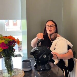 Amy with her baby pouring the all black uccello kettle in demonstration as to how it works