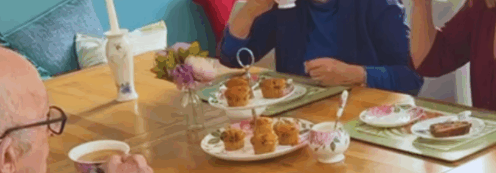 Mother, Father and daughter enjoying tea and cake in the kitchen
