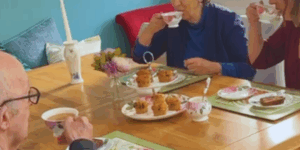 Mother, Father and daughter enjoying tea and cake in the kitchen