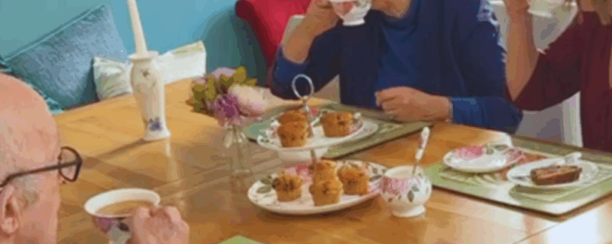 Mother, Father and daughter enjoying tea and cake in the kitchen