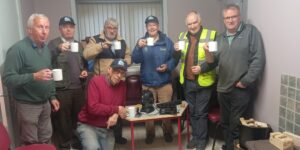 Local Men's Shed Group Photo - 7 Men's Shed Members Circle around the Uccello Kettle and enjoy a cup of tea together