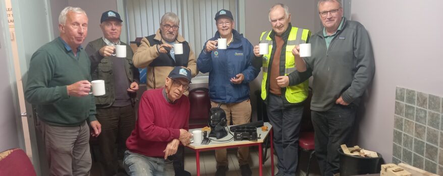 Local Men's Shed Group Photo - 7 Men's Shed Members Circle around the Uccello Kettle and enjoy a cup of tea together