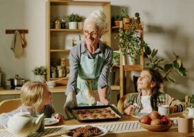 Grandmother in the kitchen baking with her 2 grandchildren