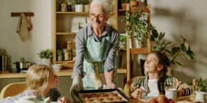 Grandmother in the kitchen baking with her 2 grandchildren