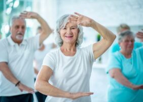 Elderly men and women doing tai chi together