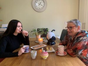 Granddaughter and grandmother enjoying tea and sweets together