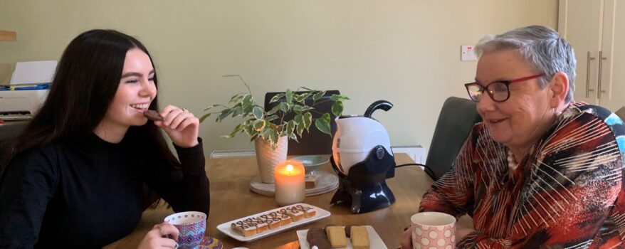Granddaughter and grandmother enjoying tea and sweets together